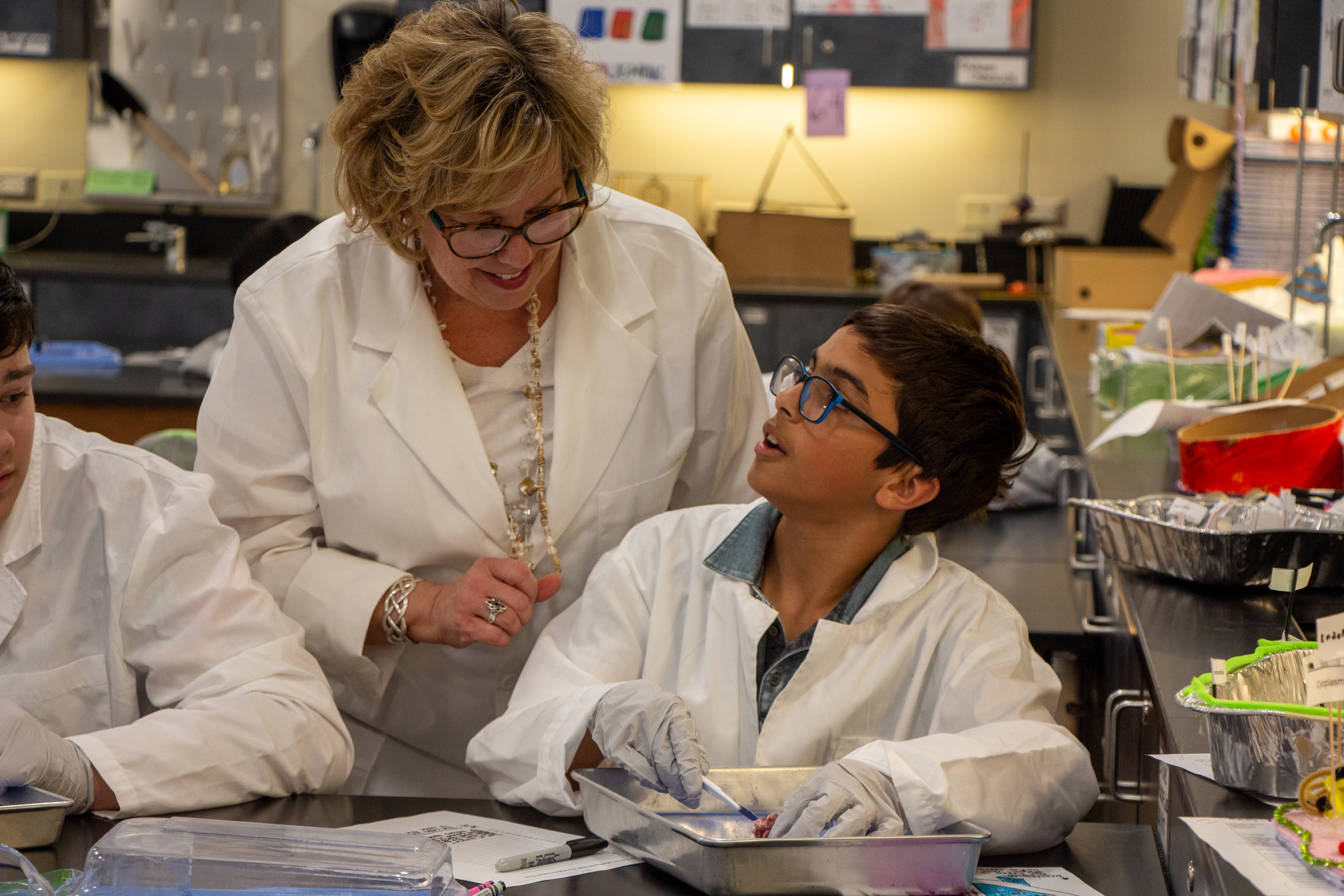 Science teacher with middle school students in science lab